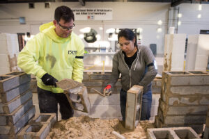 BAC craftworker teaches architect to lay block at Masonry Camp