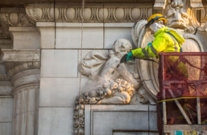 BAC restoration craftworker cleaning terra cotta facade of Old Cook County Hospital as a part of the restoration process