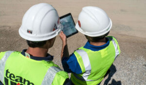 IMI technical director and contractor review plans on an tablet at a job site.